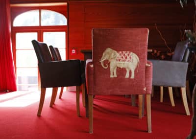Rote Stühle stehen am Tisch auf dem roten Teppich